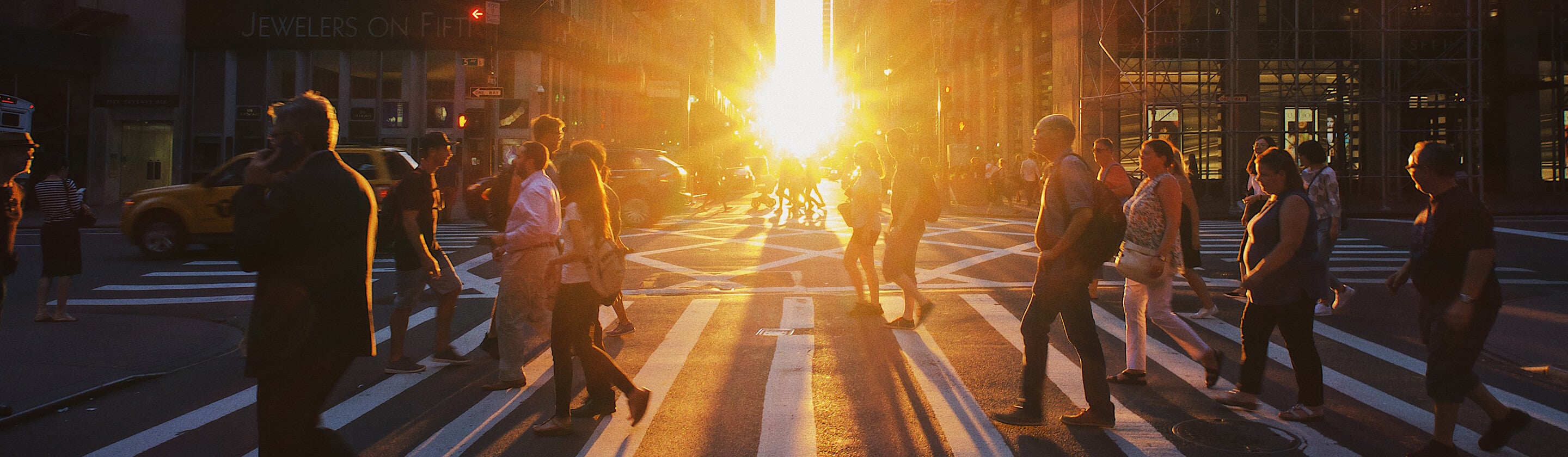 busy inner city crosswalk at sunset