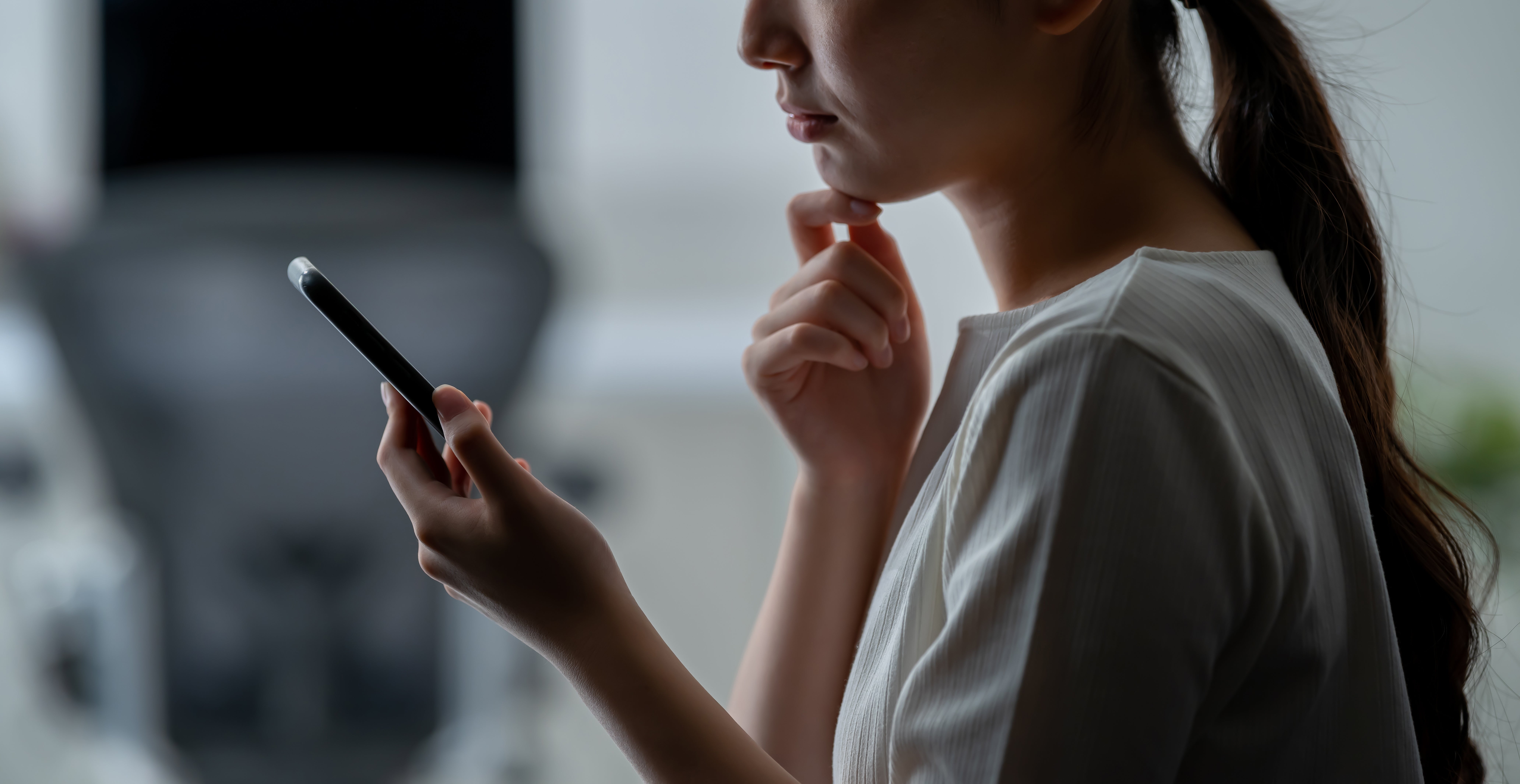 Woman looks at phone with concern