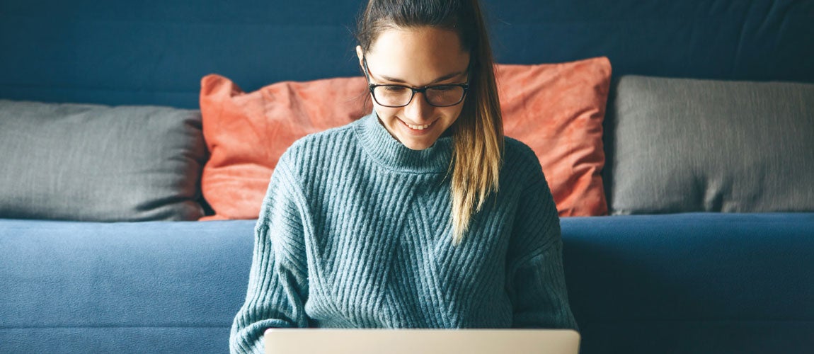 College Student looking at computer in dorm room