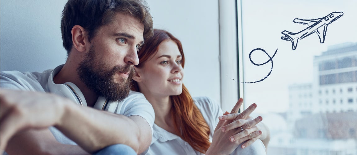 Couple sitting next to a window contemplating travel