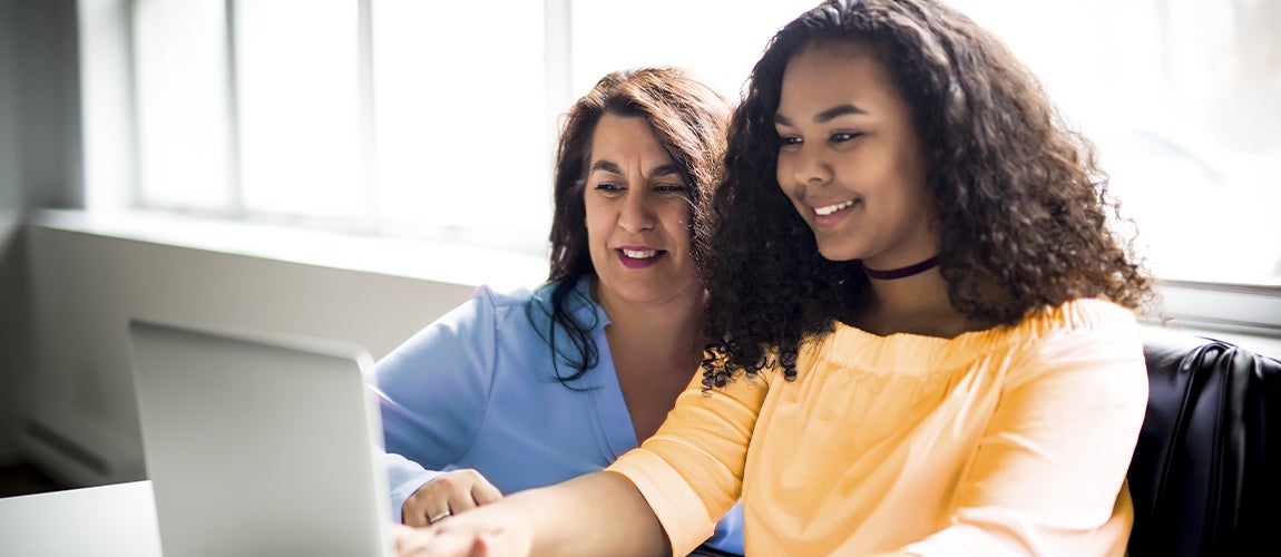 Mother and daughter looking at a laptop and learning how to invest.