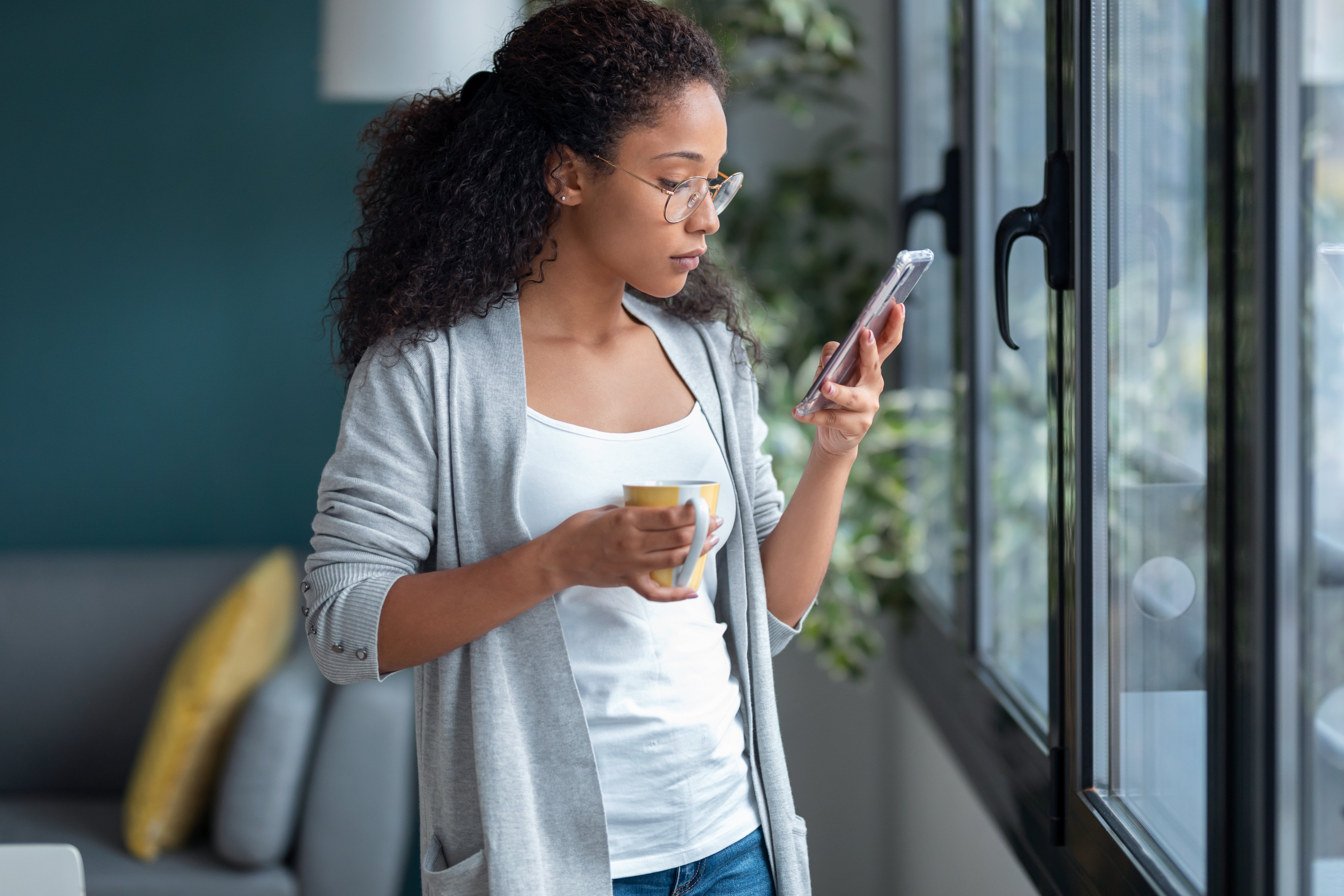 Woman reviewing a text message to determine if it is a legitimate text or if it is a smishing attempt.