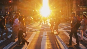 busy inner city crosswalk at sunset