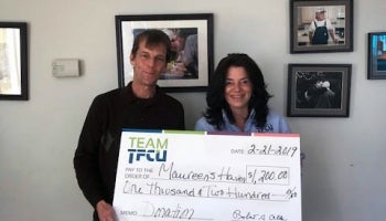 Two Teachers employees holding a Maureens Haven donation check
