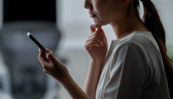 Woman looks at phone with concern