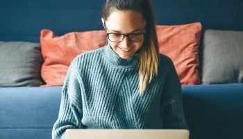 College Student looking at computer in dorm room