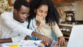 Couple reviewing monthly statements and planning a financial budget