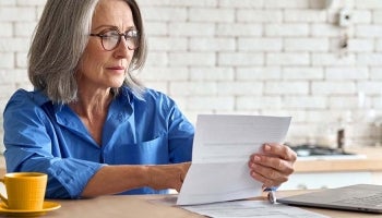 Bank customer reviewing account statement to check for banking fees that she has been charged