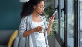 Woman reviewing a text message to determine if it is a legitimate text or if it is a smishing attempt.