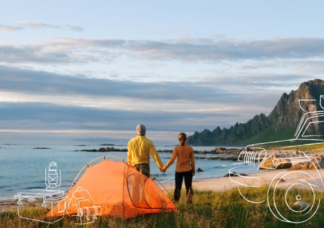 couple holding hands by tent on the beach