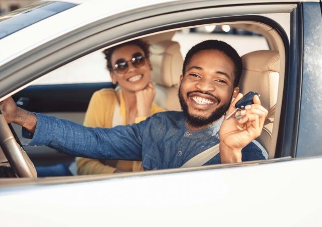 man and woman in car showing keys