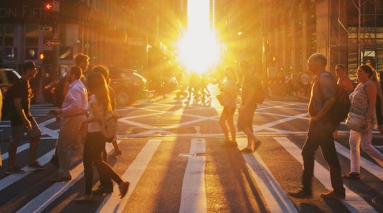 busy inner city crosswalk at sunset