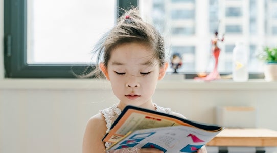 young girl reading book 