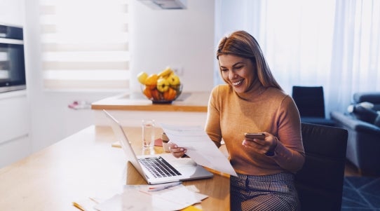 woman smile while using phone in kitchen