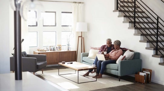 man and woman looking at a computer on a couch