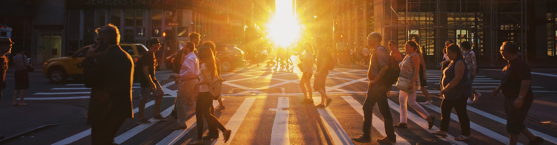 busy inner city crosswalk at sunset