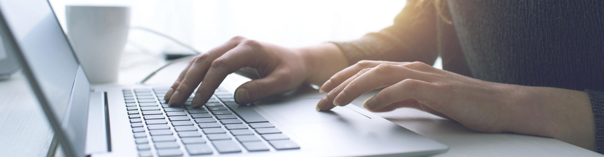 woman's hands typing on computer