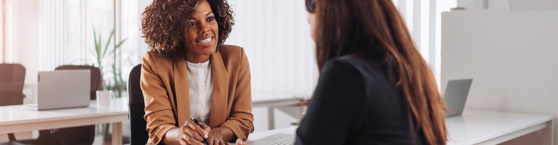 two women sitting at a desk reviewing paperwork