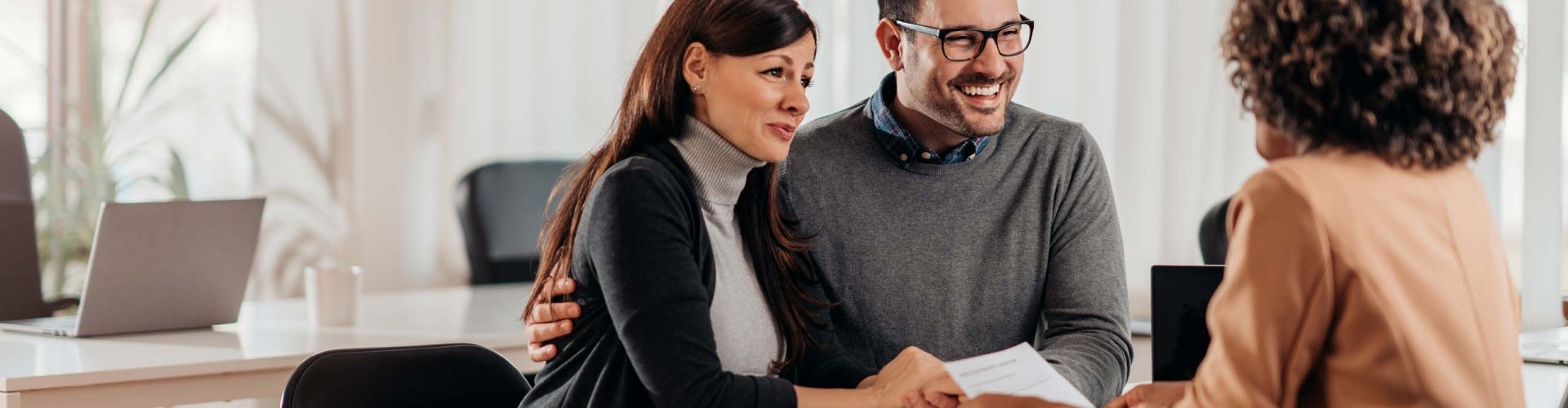 couple speaking with woman in bank lobby